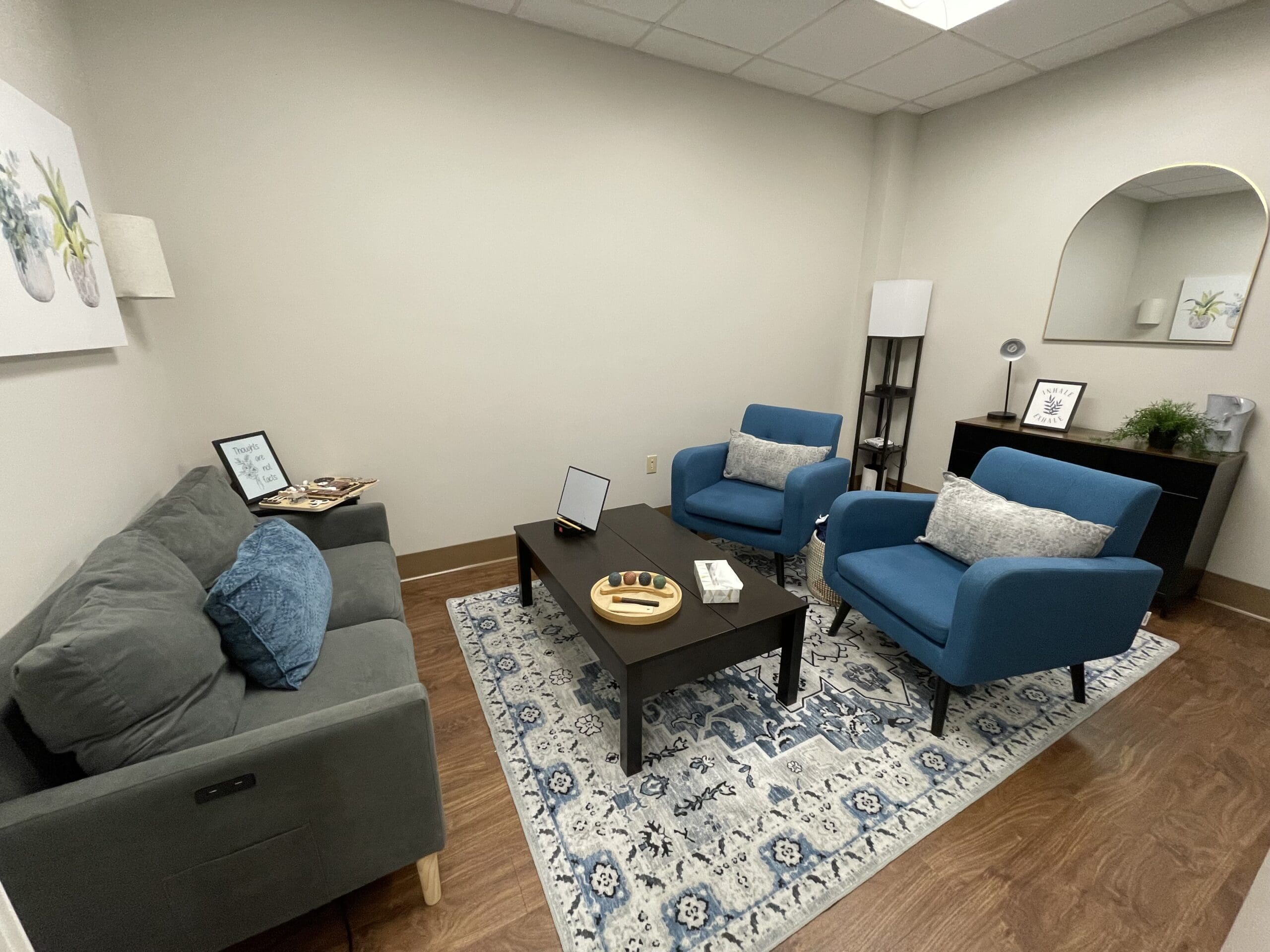 A family sitting in a circle with a therapist in a cozy office, including a teen and two parents, everyone listening attentively