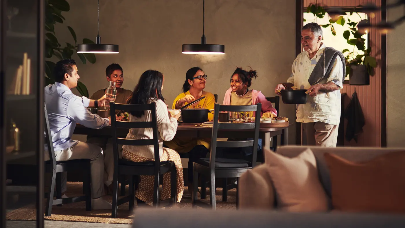 A multigenerational family talking together at a kitchen table