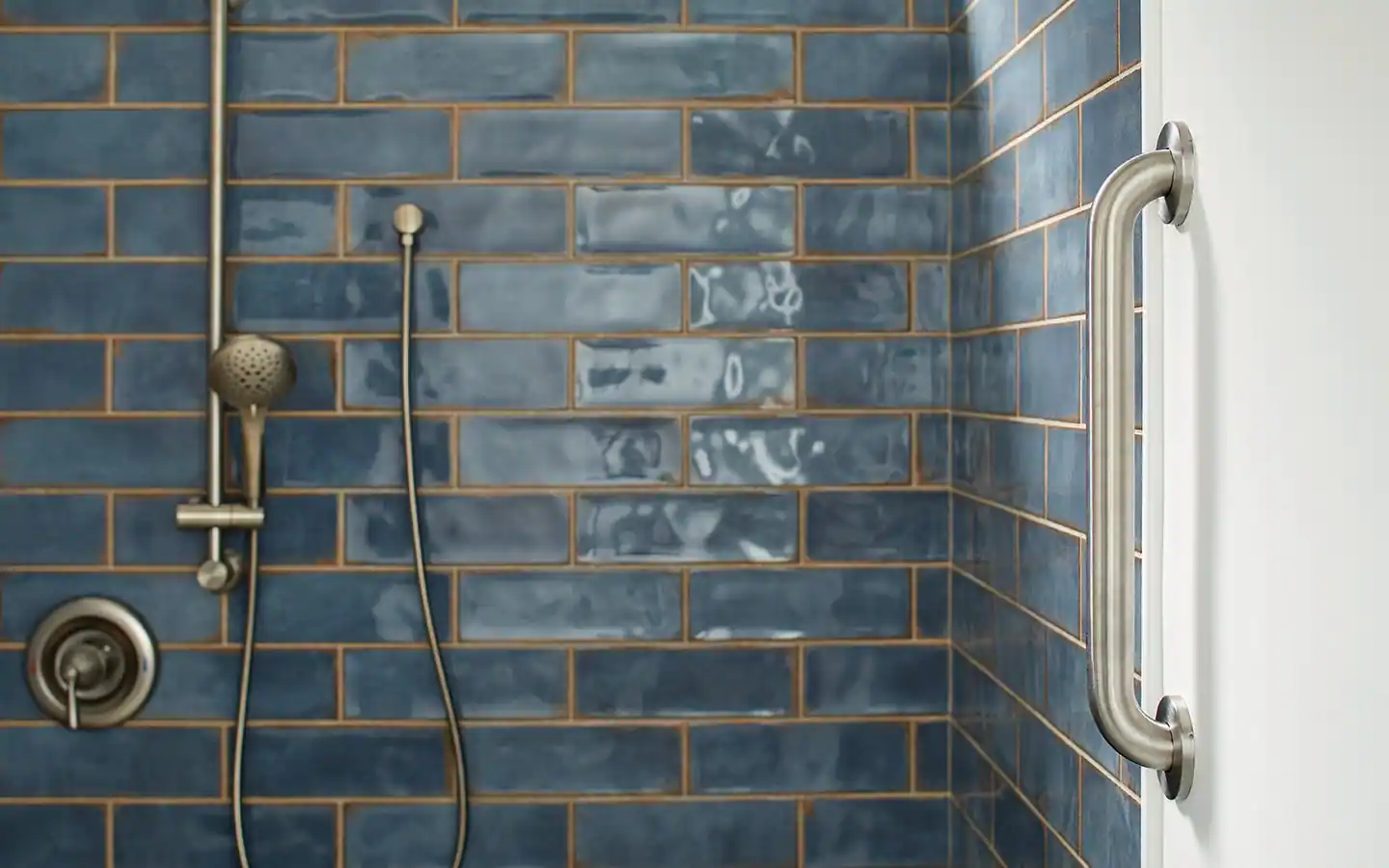 An older man and an adult child standing in a bathroom while a grab bar is installed near the shower